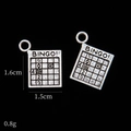 Detail of silver bingo card charms showing engraved numbers and vintage alloy texture - Bingo Card