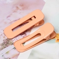 Detail of coral peach square duckbill hair clips with a minimalist hollow geometric design - Orange