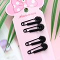 Detail van vier zwarte haarclips in de vorm van een veiligheidsspeld op roze kaart - Zwart
