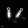 Macro shot of silver bullet alloy charms with 1.8cm length and 0.6cm diameter specs - Pencil