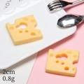 Gedetailleerd macro-opname van een 2cm miniatuur kaasplakje voor DIY poppenhuizen - Kaasplak