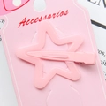 Detailed view of a pink star-shaped hair clip secured on a branded accessory display card - Pink