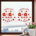 Detail van rode feestelijke raamstickers met pruimenbloesems en gelukssymbolen op glas - Vol Geluk en Veel Succes (KSJ-73)