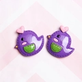 Detail van paarse cartoon vogelbedeltjes van hars met roze harten voor DIY-accessoires - Donkerpaars