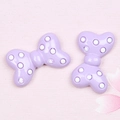 Close-up of light purple resin bow charms with white polka dots for DIY crafts - Polka Dot Bow / Light Purple