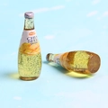 Macro shot of miniature resin mango juice bottles with chia seeds and silver caps - Mango Yellow