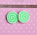 Detailed view of green and white spiral pattern resin charms for DIY craft projects - Green