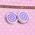 Macro detail of purple and white swirl marshmallow charms for DIY phone case crafts - Purple