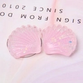 Vue macro de breloques en forme de coquillage en résine rose avec paillettes irisées - Rose Clair