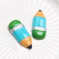 Detailed macro of vibrant resin pencil charms with glitter accents on a white tray - Blue