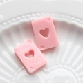 Vue macro d'accessoires de cartes à jouer en résine rose pour coques de téléphone - Rose Pêche