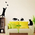 Detail view of black cat silhouette wall stickers decorating a living room wall - Black Silhouette Cat Catching Butterfly (KS084)