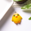 Detailed macro view of a cute yellow resin chick pendant with a pink bow and metal hook - With Eye Screw / Pleading Chick With Bow