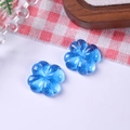 Nahaufnahme von zwei lichtdurchlässigen blauen Harzblumen mit Glitzer für DIY-Schmuck - Blau