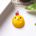 Detailed view of yellow resin chick charm with red heart and silver metal loop - With Eye Screw / Blushing Chick Front View