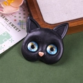 Detailed macro view of black resin cat head with vibrant blue glass eyes and pink heart nose - Blue And Yellow Gem Eyes