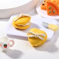 Macro-opname van gele hartvormige macaron bedeltjes met witte strikjes voor DIY - Hartvorm Geel