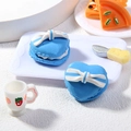 Makro-Detail des himmelblauen Herz-Macarons mit blau-weißer Schleife auf einem Tablett - Herzförmig Blau