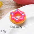 Macro detail of 2.3cm resin doughnut charm with pink frosting and colorful sugar beads - Yellow And Rose Red Jam
