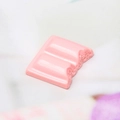 Macro detail of a pink resin chocolate charm with bite mark for DIY crafts and decor - Pink Bitten Style