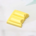 Macro detail of a 3D yellow resin chocolate cabochon with realistic bite mark for DIY crafts - Yellow Bitten Style