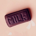 Macro detail of dark brown resin chocolate charm with MILK text for DIY crafts - Matte Polymer Clay Style