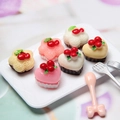 Miniature resin heart strawberry cakes with faux cherry decor on a white serving tray - Multicolor