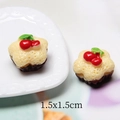 Detail view of two miniature 1.5x1.5cm resin star cakes with cherry topping for dollhouses - Flower Cake - Yellow
