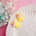 Detailed view of yellow bow cookie resin charms on a white porcelain decorative plate - Yellow