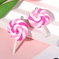 Dettaglio macro di due ciondoli a forma di lecca-lecca in argilla rosa e bianca con anelli - Con Vite ad Occhiello / Rosa e Bianco