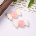 Nahaufnahme von rosa-weißen Harz-Bonbons für DIY Haarschmuck und Bastelarbeiten - Creme und Rosa