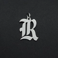 Macro-opname van een gepolijste roestvrijstalen gotische letter R hanger voor sieraden - Letter R