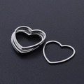 Macro shot of silver heart-shaped stainless steel DIY pendants on a textured black base - Heart Style (T940) / Silver