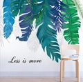 Détail d'un sticker mural feuille tropicale avec texte 'Less is more' sur mur blanc - Plantes Vertes (HT-94015)