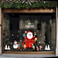 Detalle de pegatinas navideñas para ventanas con Papá Noel y texto sobre cristal - Papá Noel Fuera de Caja de Regalo Con Pingüino Esquiando (6281)
