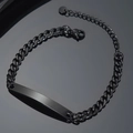 Macro view of polished black stainless steel Cuban link bracelet with curved ID plate - Black Cuban Chain