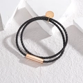 Primer plano de una pulsera de cuero trenzado negro de doble capa con detalles en oro rosa - Cuerda Negra (Oro Rosa)