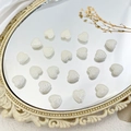 Macro-opname van crème hartkralen met kaviaartextuur op vintage decoratieve spiegel - Hart Stijl