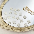 Witte parelmoer strik bedel voor DIY sieraden op een antieke spiegel achtergrond - Strik Stijl