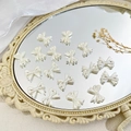 Onregelmatige parelwitte strikkralen voor DIY-armbanden op een elegante vintage spiegel - Strik Stijl