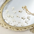 Gepolijste zilveren metalen kruiskralen voor DIY-sieraden op een vintage spiegeltray - Kruis Stijl