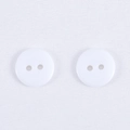 Set di due bottoni tondi in resina bianca con due fori su sfondo di tessuto bianco fine - Bianco