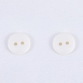 Bottoni tondi minimalisti in resina bianca a due fori su trama fine di tessuto bianco - Beige
