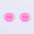 Set di due bottoni tondi in resina rosa con finitura liscia su tessuto bianco ruvido - Rosa