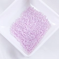 Haufen 2mm lavendelfarbene Glasperlen für DIY-Schmuck in einer weißen Keramikschale - Fliederfarben (Nr. 12)
