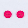 Bottone rotondo in resina rosa scuro a due fori per cappotti su tessuto bianco - Rosa Rossa