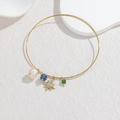 Detail of 18k gold open bangle featuring pearl, blue marble, star, and green crystal charms - Blue and Green Bead Star Style (OLBB1225-lvlan)