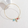 Détail d'un bracelet en or 18k avec perle bleue, croix, cristal et perle baroque - Style Croix Perle Rouge et Bleue (OLBB1224-honglan)