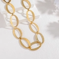 Détail macro du collier chaîne en or 18k avec maillons géométriques texturés - Style A-Or (Collier)