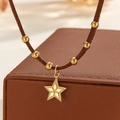 Detailed view of 18k gold star pendant with brown suede cord on a luxury display box - Smooth Star Style (S-N2298-A)